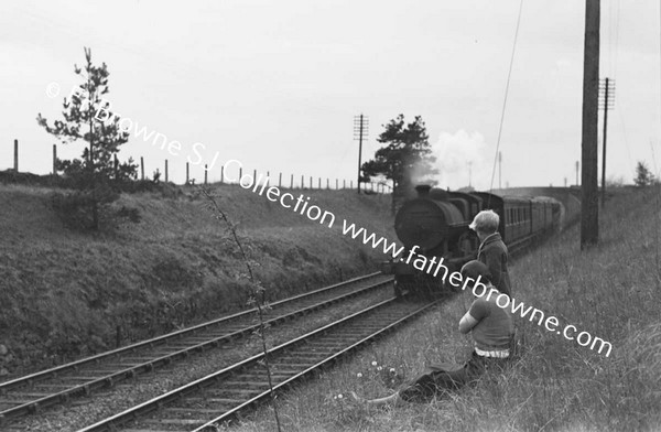 BOYS WATCHING AND WAITING AT RAILWAY EMBANKMENT